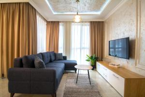 sala de estar con sofá azul y TV en Odrys Apartments en Plovdiv