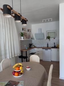 a kitchen with a table with a bowl of fruit on it at Apartman Betty in Šibenik