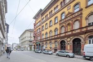 un bâtiment avec des voitures garées sur le côté d'une rue dans l'établissement Cozy & Central apartment with 2-bedroom, à Budapest