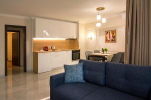 a living room with a blue couch and a kitchen at Odrys Apartments in Plovdiv