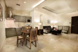 a kitchen and living room with a table and chairs at Aswar Hotel Suites Riyadh in Riyadh