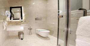y baño con aseo, lavabo y ducha. en Aswar Hotel Suites Riyadh en Riad