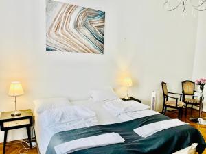 a bedroom with a large bed with a painting on the wall at City Rooms in Budapest
