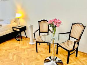 a room with a glass table and two chairs and a bed at City Rooms in Budapest
