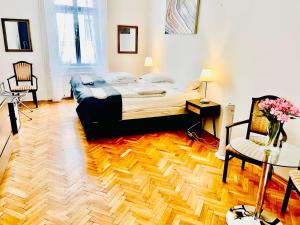 a bedroom with a large bed and a wooden floor at City Rooms in Budapest