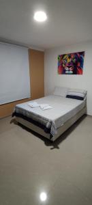 1 dormitorio con 1 cama grande y pantalla de proyección en Hermosa casa amoblada, en Barranquilla