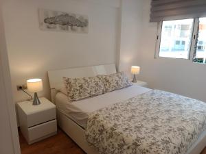 um quarto branco com uma cama e 2 candeeiros em Le Panorama Appartement em El Campello