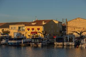 un gruppo di imbarcazioni ormeggiate nell’acqua vicino agli edifici di Logis Heraclee a Saint-Gilles