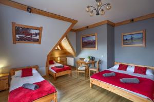 a bedroom with two beds and a table in it at U Studniara in Murzasichle