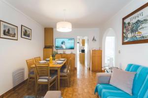 sala de estar con mesa y sofá azul en Best Houses 49 - Tiago´s Surf Beach House, en Atouguia da Baleia