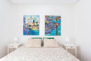 sypialnia z łóżkiem z dwoma obrazami na ścianie w obiekcie Apartamento en playa de castelldefels. Ubicación inmejorable! w mieście Castelldefels