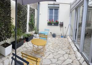 a patio with a table and chairs on a patio at Hotel Lilas Gambetta in Paris