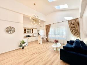 a living room with a blue couch and a kitchen at Residence Odaile #9 in Otopeni