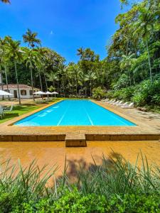 an empty swimming pool with trees in the background at Locanda Bela Vista in Itaipava