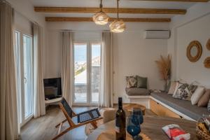 a living room with a table and a couch at Epithea Suites Kythnos 1 με ιδιωτική πισίνα in Kithnos