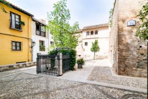 un callejón en una ciudad con edificios amarillos y blancos en Wekey Homes Albaicin, A los Pies de la Alhambra, en Granada