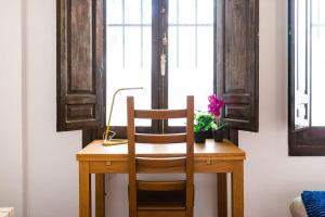 una mesa de madera con una silla y una planta. en Wekey Homes Albaicin, A los Pies de la Alhambra, en Granada