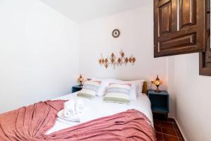 1 dormitorio con 1 cama con sábanas y almohadas blancas en Wekey Homes Albaicin, A los Pies de la Alhambra, en Granada