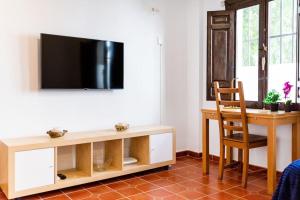 sala de estar con escritorio y TV en la pared en Wekey Homes Albaicin, A los Pies de la Alhambra, en Granada