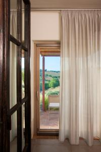 een kamer met een deur en een raam met uitzicht bij Casale Sterpeti in Magliano in Toscana