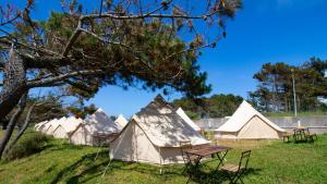 grupa namiotów w polu ze stołem w obiekcie Glamping Atlántico w mieście Ferrol