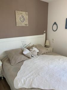 a bedroom with a white bed with pillows on it at domaine du green castelgreen in Rivières +4 photos