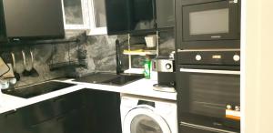 a kitchen with a washing machine and a microwave at Luxury apartment near metro by hospitality gr in Athens