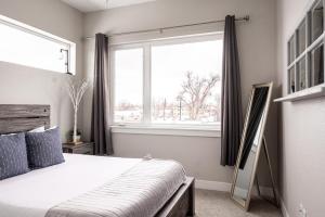 a bedroom with a bed and a large window at Contemporary Zen Townhome with a View - Wash Park in Denver