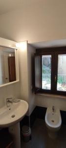 baño con lavabo y aseo y ventana en Casa Marianna en Fontechiari