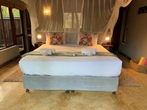 Un pat sau paturi într-o cameră la Hoedspruit Raptors Lodge N16