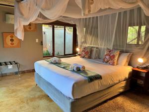 1 dormitorio con 1 cama con 2 toallas en Hoedspruit Raptors Lodge N16, en Hoedspruit