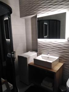 uma casa de banho com um lavatório, um WC e um espelho. em Apartments F&T em Mošćenička Draga