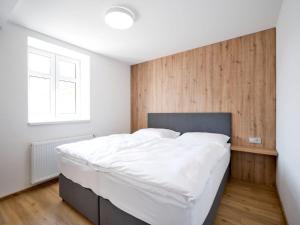 a bedroom with a large bed with a wooden wall at Penzion SALAŠ in Salaš