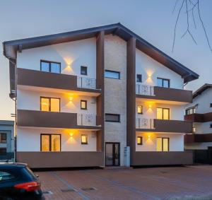 un edificio de apartamentos con balcones y aparcamiento en Residence Odaile #1 en Otopeni