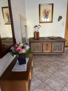 a room with a table with a vase of flowers on it at Ferienzimmer Reurieth in Reurieth +8 photos
