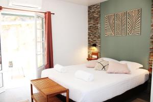 1 dormitorio con 1 cama con sábanas blancas y almohadas rosas en Guesthouse Aljezur Center, en Aljezur