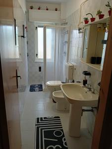 uma casa de banho branca com um lavatório e um WC em Seafront em San Sostene Marina