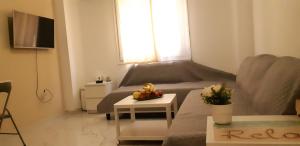 a living room with a couch and a table with fruit on it at Luxury apartment 3 rooms near metro in Athens
