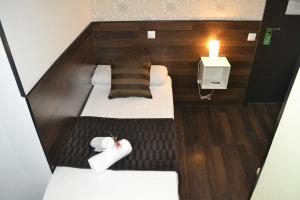 mały pokój z 2 łóżkami i świecą w obiekcie Hostal El Brezo w Madrycie