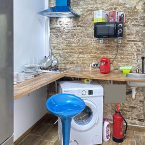 a kitchen with a washing machine and a blue stool at CAMP NOU & FiRA BUSINESS LOFTS in Barcelona