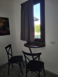 una stanza con due sedie e un tavolo e una finestra di Casa MaLa’ a Ceprano