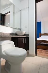 a bathroom with a toilet and a sink and a bed at HOTEL YANUBA CAMPESTRE in Pereira