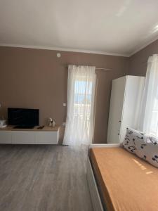 a bedroom with a bed and a tv and a window at Jurič in Rogoznica