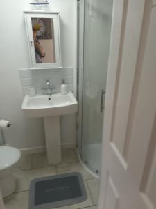 a white bathroom with a sink and a shower at The Annexe in Rothwell