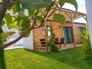 a backyard with a wooden pergola and chairs at Tiny Village Mamaia Nord - House 2 in Mamaia Nord