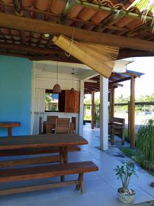 a patio with wooden benches and a table at Pousada Tulum in Barra Grande