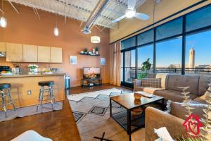 a living room and kitchen with a couch and a table at Elevated Route 66 ABQ Penthouse- An Irvie Home in Albuquerque