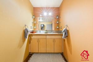 a bathroom with a sink and a mirror at Elevated Route 66 ABQ Penthouse- An Irvie Home in Albuquerque