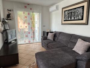 a living room with a couch and a tv at Apartments Roxsi in Novalja