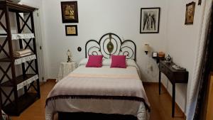 a bedroom with a large bed with pink pillows at Casa Santana Segura in Tejeda